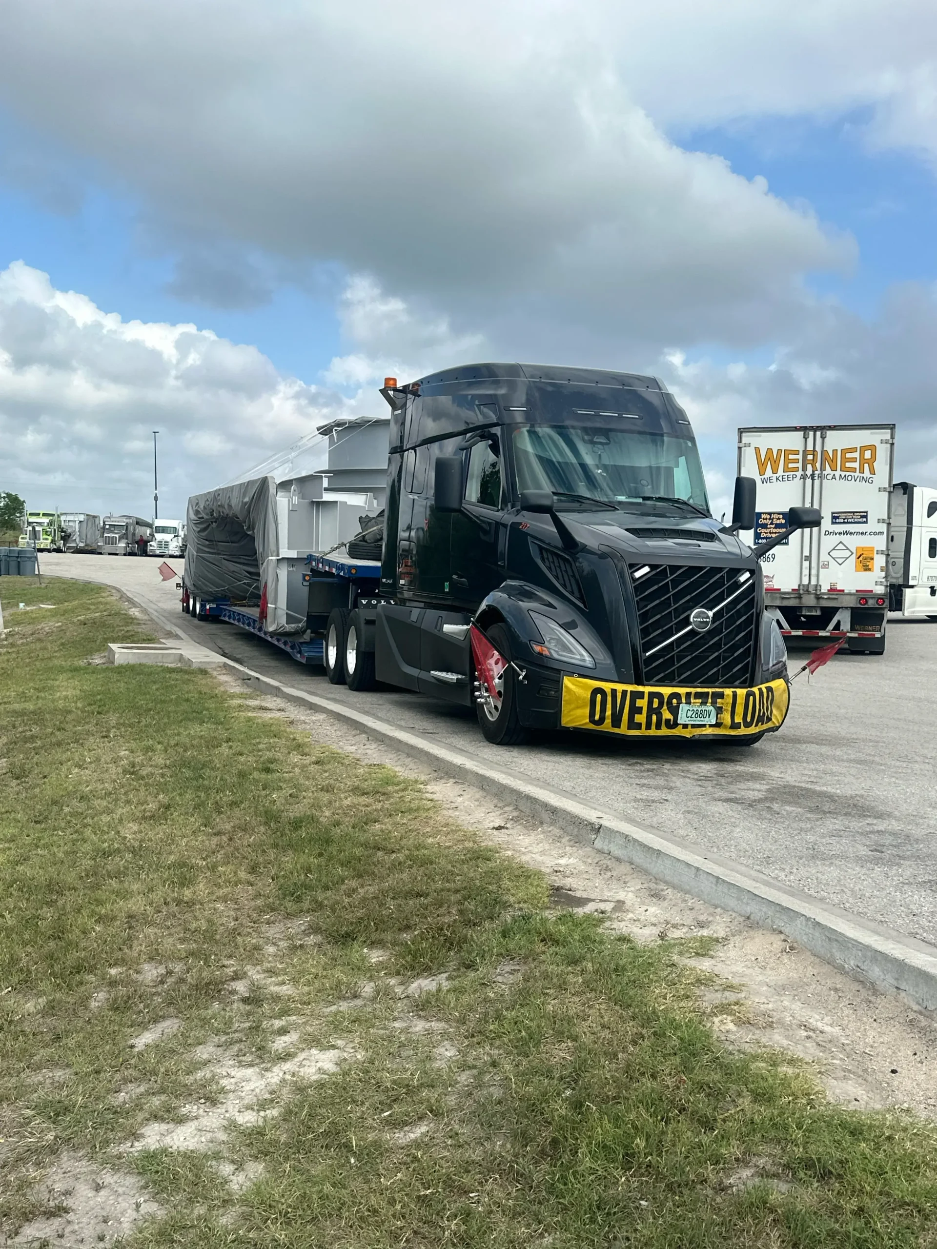 Tavus Transportation tractor hauling a permitted oversize load on a lowboy trailer